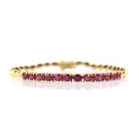 Ruby and 14 ct yellow gold bracelet; twelve oval faceted rubies, estimated total weight 2.96 carats,