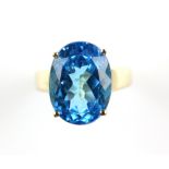 Blue topaz cocktail ring, oval cut blue topaz weighing an estimated 12.60 carats, in a four claw