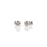 Two single stone diamond stud earrings; one estimated at 0.88 carats, the other estimated at 0.76