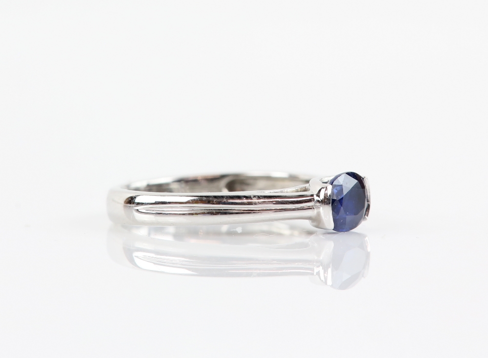 Contemporary sapphire ring, oval cut sapphire, estimated weight 0.90 carats, mount stamped 18 ct, - Image 2 of 3