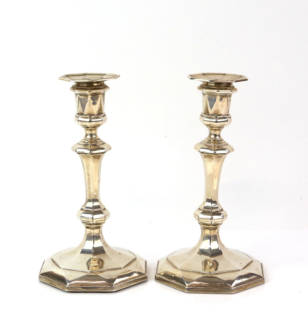 George V pair of silver candlesticks, the octagonal facetted bases filled, by James Deakin & Sons (