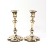 George V pair of silver candlesticks, the octagonal facetted bases filled, by James Deakin & Sons (