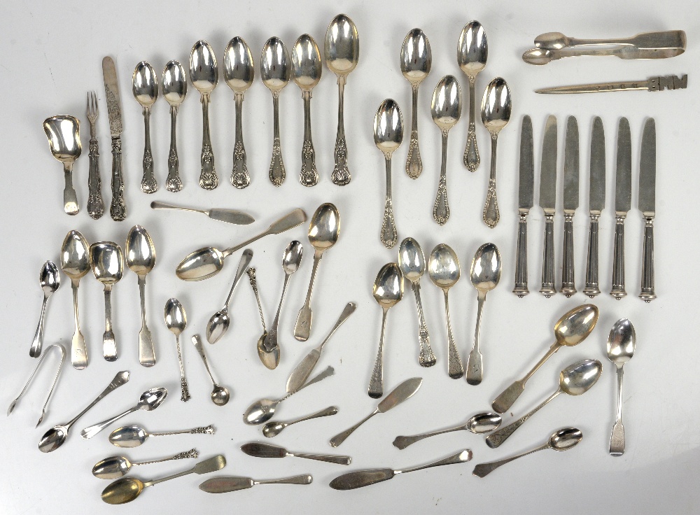 Large group of silver teaspoons and other items, including butter knives, caddy spoons, sugar