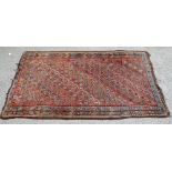 Persian rug with repeating floral motifs on a red ground, 203 x 113cm