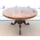 19th century rosewood breakfast table, the circular top on floral carved splayed legs and castors,