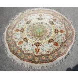 Circular Persian rug, central floral medallion and scrolling stylised flowers on a cream ground,