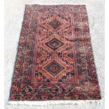 Persian rug with triple diamond medallions on a dark blue ground with star and floral motifs, within
