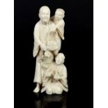 Late 19th century Japanese ivory okimono of a man carrying his son on his shoulder with another