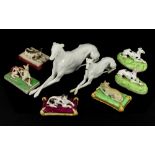 Porcelain models of recumbent dogs, three probably Chamberlain's Worcester dogs seated on