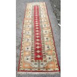 Persian style red ground runner, with repeating geometric motifs contained within geometric and