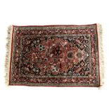 Iranian part silk prayer rug, floral decoration on a rouge ground within stylised floral borders,