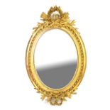 Gilt gesso oval mirror the top decorated with flowers and foliage with beaded inner decoration and