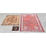 Persian style rug with repeating geometric and floral panels on a red ground within geometric and