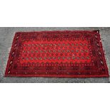 Bokhara style rug, with repeating gul motifs on a red ground contained by geometric borders, 200 x