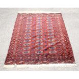 Bokhara rug with repeating gul motifs on a red ground within stylised floral borders, 176 x 136cm