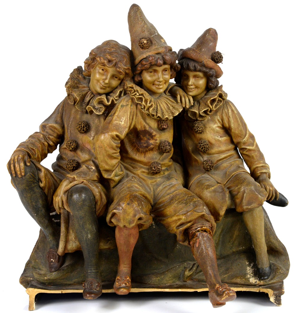 Goldscheider figure of three children dressed as clowns, on a shaped base, impressed marks and