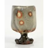 Small studio pottery goblet, naïvely formed with pinched stem, white and tan coloured circular