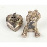Silver model of a teddy bear and a silver teddy bear topped heart shape box with articulated head