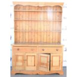 20th century pine dresser with three tier plate rack above two short drawers and two cupboards. 230H