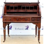 A 19th century mahogany cylinder desk the roll top opening to reveal compartments and leather