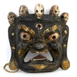 Balinese Barong carved wooden mask, with open mouth and eyes and adorned with skulls, having