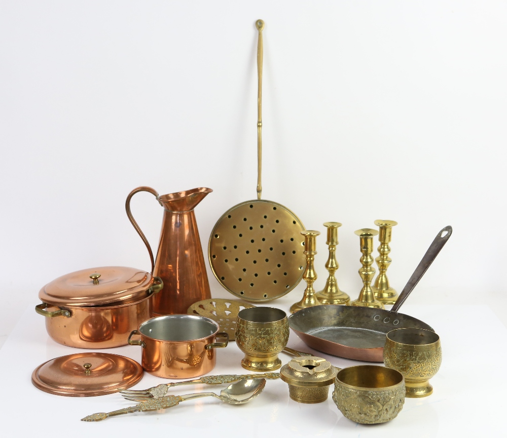 Brass and copper items to include two pairs of brass candle sticks, copper pans, trays, bowls and