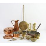 Brass and copper items to include two pairs of brass candle sticks, copper pans, trays, bowls and