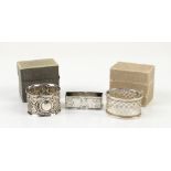 Two boxed silver napkin rings and a novel Webster sterling rectangular napkin ring decorated with