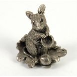 Silver model of Mouse sat on an oak leaf with an acorn by feet and an acorn kernel in front paws, by