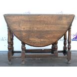 19th century oak gateleg oval dining table on turned legs untied by stretchers. 75H x 137W x 107D.