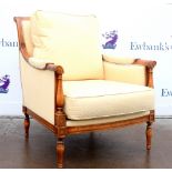 20th century beech framed armchair with scrolling details and trumpet legs.