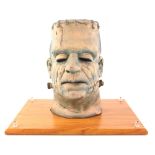 Frankenstein latex model head in Perspex case, overall 31 x 36 cm.