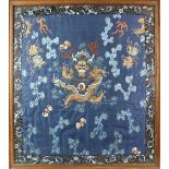 A framed Chinese textile of a coiled dragon, overall dimensions including frame about 65 x 58 cm;