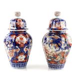 An associated pair of Japanese Imari vases; each one with domed cover and reticulated knop finial,