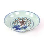 A doucai style dish decorated with flowering peaches and rockwork; the base with Qianlong six-