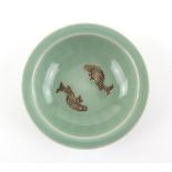 A small celadon bowl in the Song or Ming style, decorated with two fish in the well, 13.5 cm