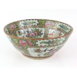 A Canton famille rose bowl, decorated with typical panels of Manchu/Chinese figures and Natural