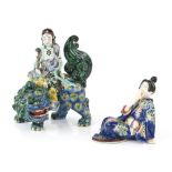 A Japanese porcelain figure of a Buddhist Deity, seated on the back of a karashishi, 21 cm high;