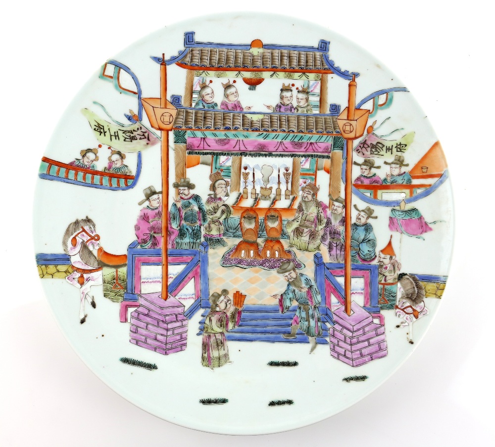 A famille rose dish of circular form decorated with a narrative scene of figures seated for