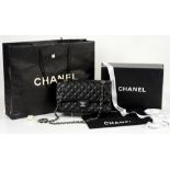 Classic Chanel double flap bag in black caviar leather with silver hardware. Authenticity card