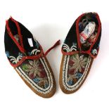 A pair of 19th century moccasins with coloured glass and shell bead floral insteps and ankle