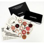 A collection of vintage Coco Chanel promotional badges for lipstick (12) in a black cotton