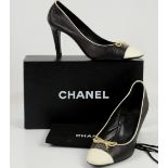 Black leather Chanel high heel shoes with off white toe caps with bow and stitched logo with box and