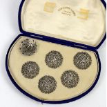 A set of six white metal floral pierced buttons 3.2cm diameter cased H Khaimchand Tejoomal Rangoon