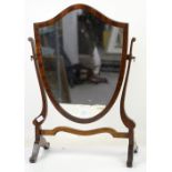 19th century mahogany shield shaped bedroom mirror on splayed feet united by a stretcher. 60H