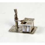Dutch silver miniature of a chef at a stove holding a pan