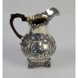 Victorian silver milk jug with a leather covered handle, with floral embossed decoration, by Charles