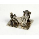 Dutch silver miniature of a woman holding a baby, sitting on a stool next to a crib