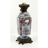 Imari patterned oil lamp on gilt metal base with scroll feet. H28cm