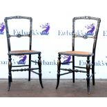 Pair of ebonised and mother of pearl inlaid chairs with caned seats